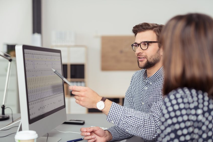 geschäftsmann erklärt seiner kollegin etwas am computer